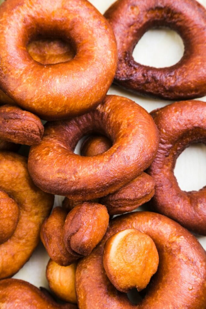 full-frame-brown-fresh-donuts-white-surface_23-2148123854